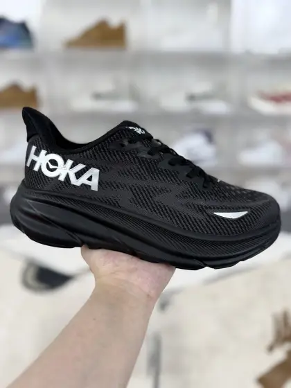▪️BA纯原 HOKA ONE ONE Clifton 9 舒适运动耐磨 低帮跑步鞋 男女款 黑银 ▪️ (36 36.5 37 38 38.5 39 40 40.5 41 42 42.5 43 44 44.5 45) ▪️货号:1141470-BBLC/1141490-BBLC ▪️HOKA ONE ONE Clifton 9是HOKA克利夫顿系列的第九代升级款跑步鞋.采用全新升级的超轻泡棉中底,通过发泡技术革新,中底厚度增加3mm(约32mm),但鞋重比上一代轻4g,约246g(42码).中底材料更柔软、回弹更好,提供更强缓冲,同时保持轻盈,适合长距离跑步,减少足部疲劳.延续HOKA的Meta-Rocker弧形鞋底设计,前后掌落差5mm,帮助身体重心自然从后掌向前掌过渡,步伐更顺畅,推动跑者向前,省力且稳定.采用透气弹力工程网面,通过提花工艺打造更精细的网孔,更轻盈、透气,同时增加鞋面强度和支撑性.鞋口圈弹软海绵填充,搭配加长拉襻和单边鞋舌稳定片,穿脱方便,防止掉跟和鞋舌挪动.优化橡胶外底排布,增加易磨损部位的橡胶,兼顾轻便、耐磨性和防滑性,适合公路和跑道场景.适合公路跑、日常训练、马拉松比赛,尤其适合追求舒适缓震、自然步态的跑者,也适合大体重跑者或关节敏感人群.
